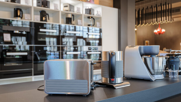 Brand new toaster, kettle and food processor in apliance store showroom, ovens and other home appliance at background