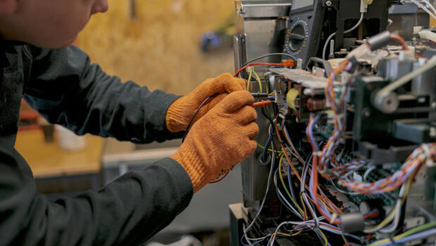 Close up of professional worker fixing coffee machine in workshop. High quality photo